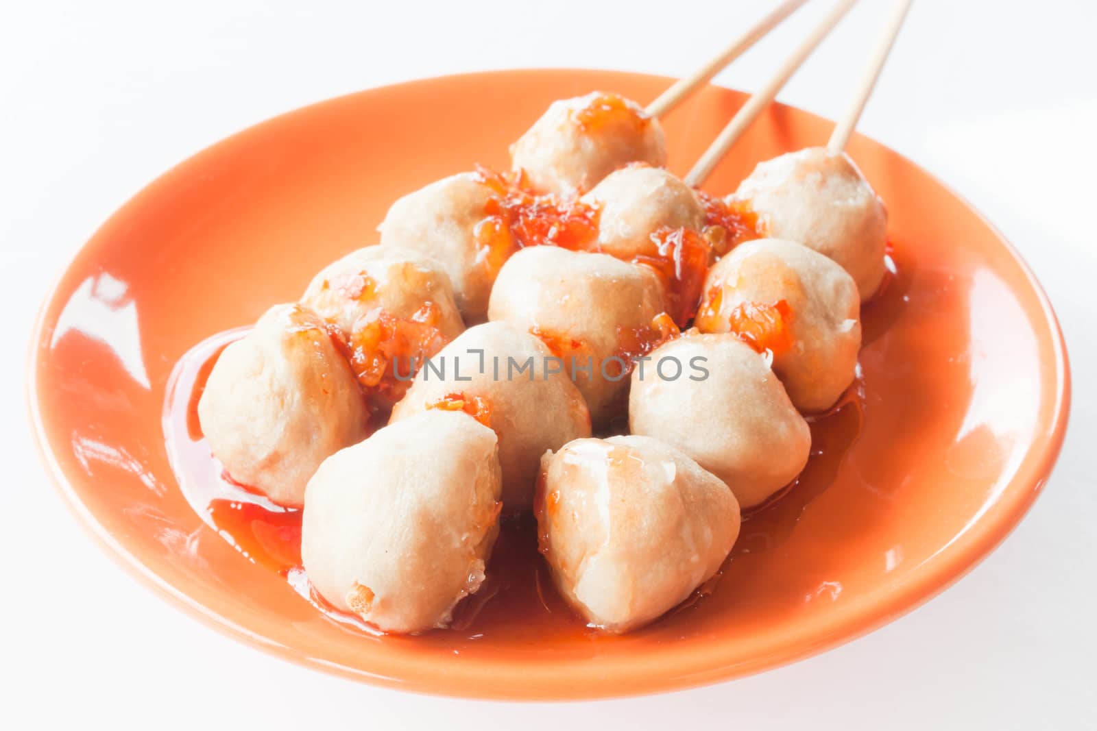 Mini pork balls in orange dish on clean table by punsayaporn