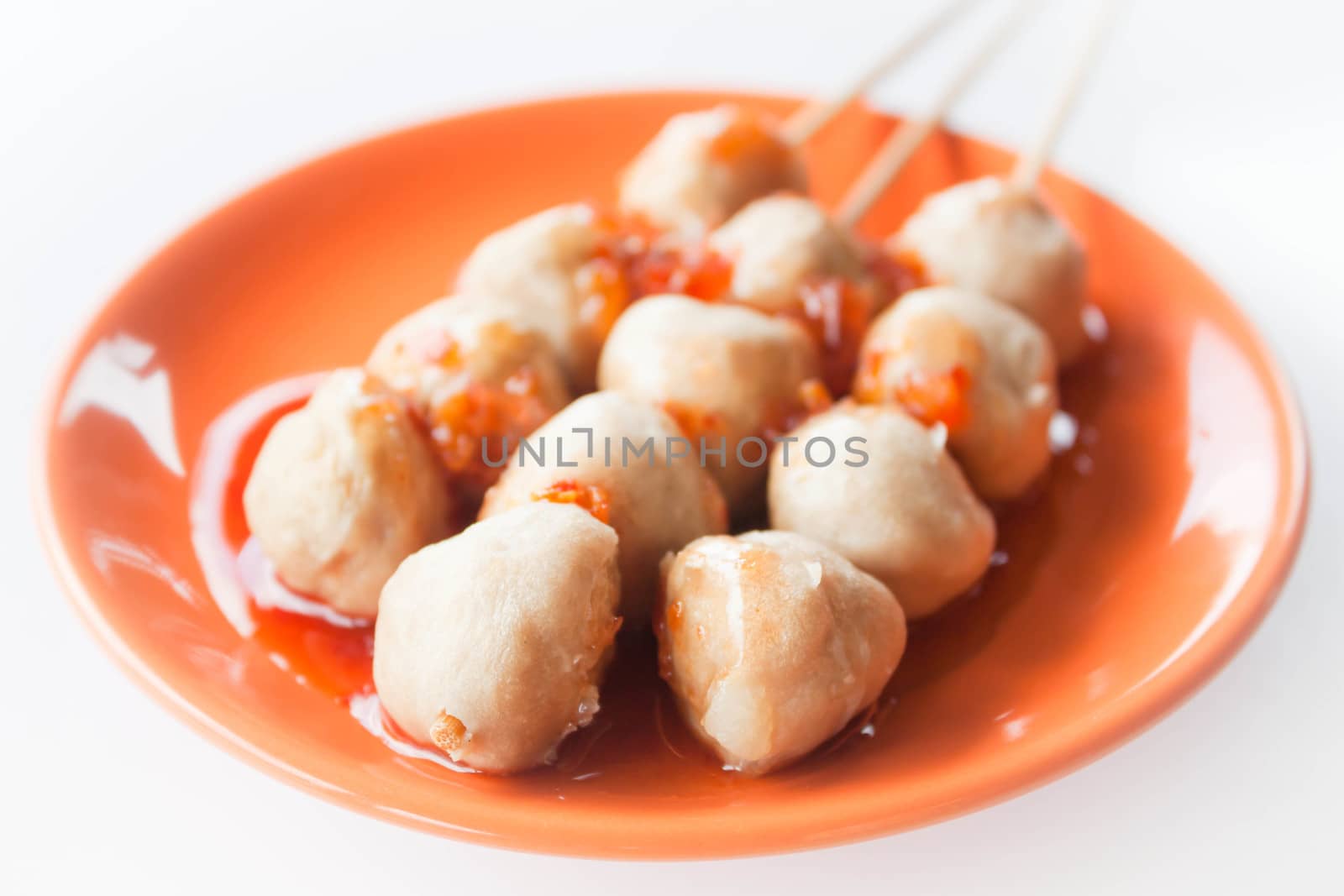 Mini pork balls in orange dish on clean table by punsayaporn