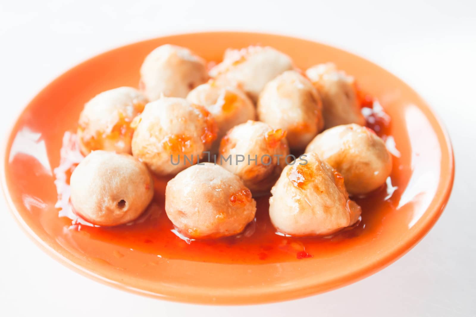 Mini pork balls in orange dish on clean table by punsayaporn