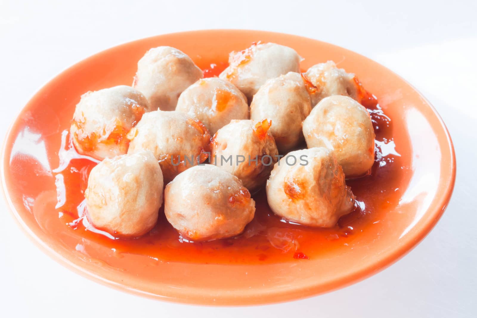 Mini pork balls in orange dish on clean table