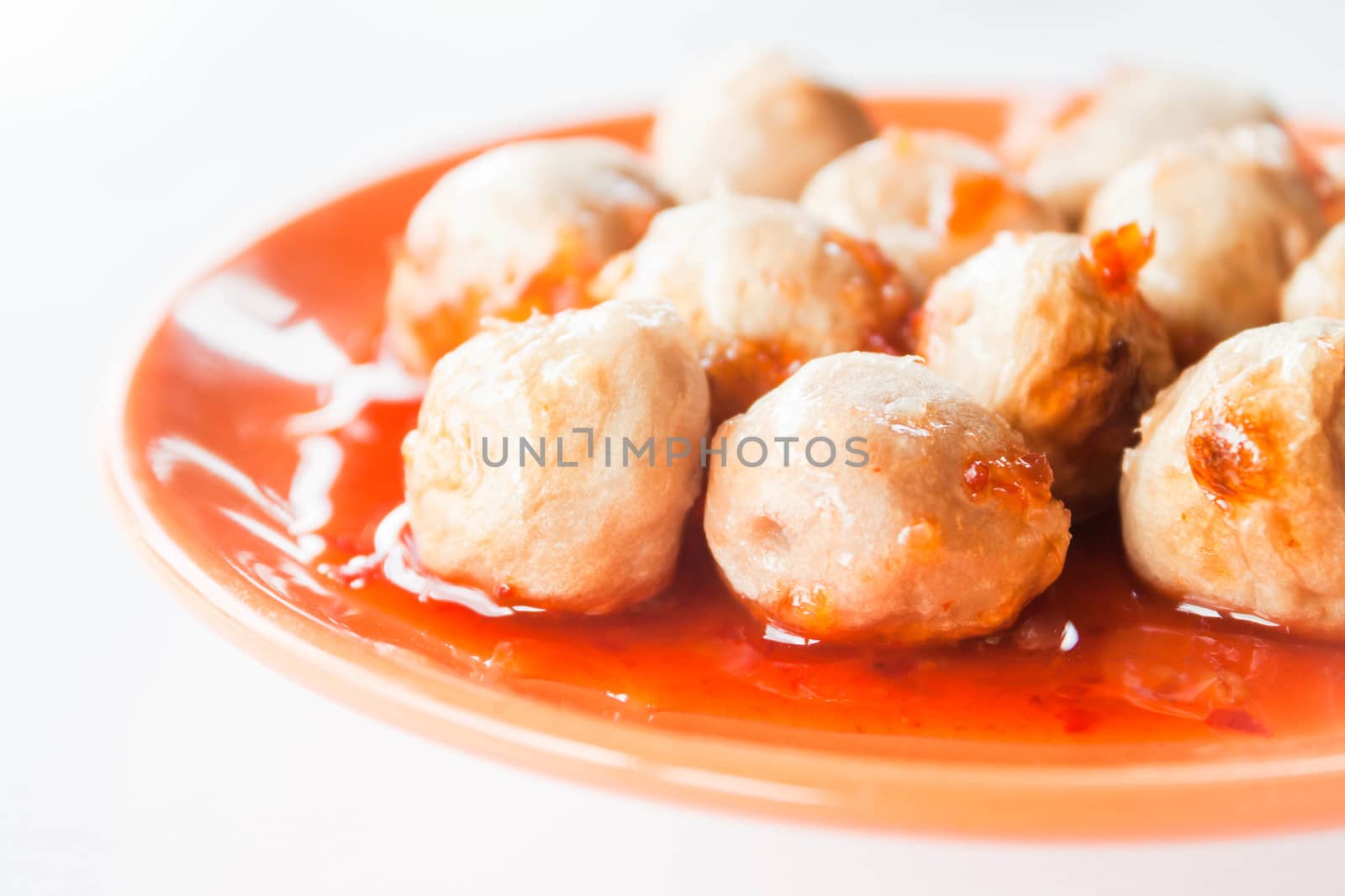 Mini pork balls in orange dish on clean table