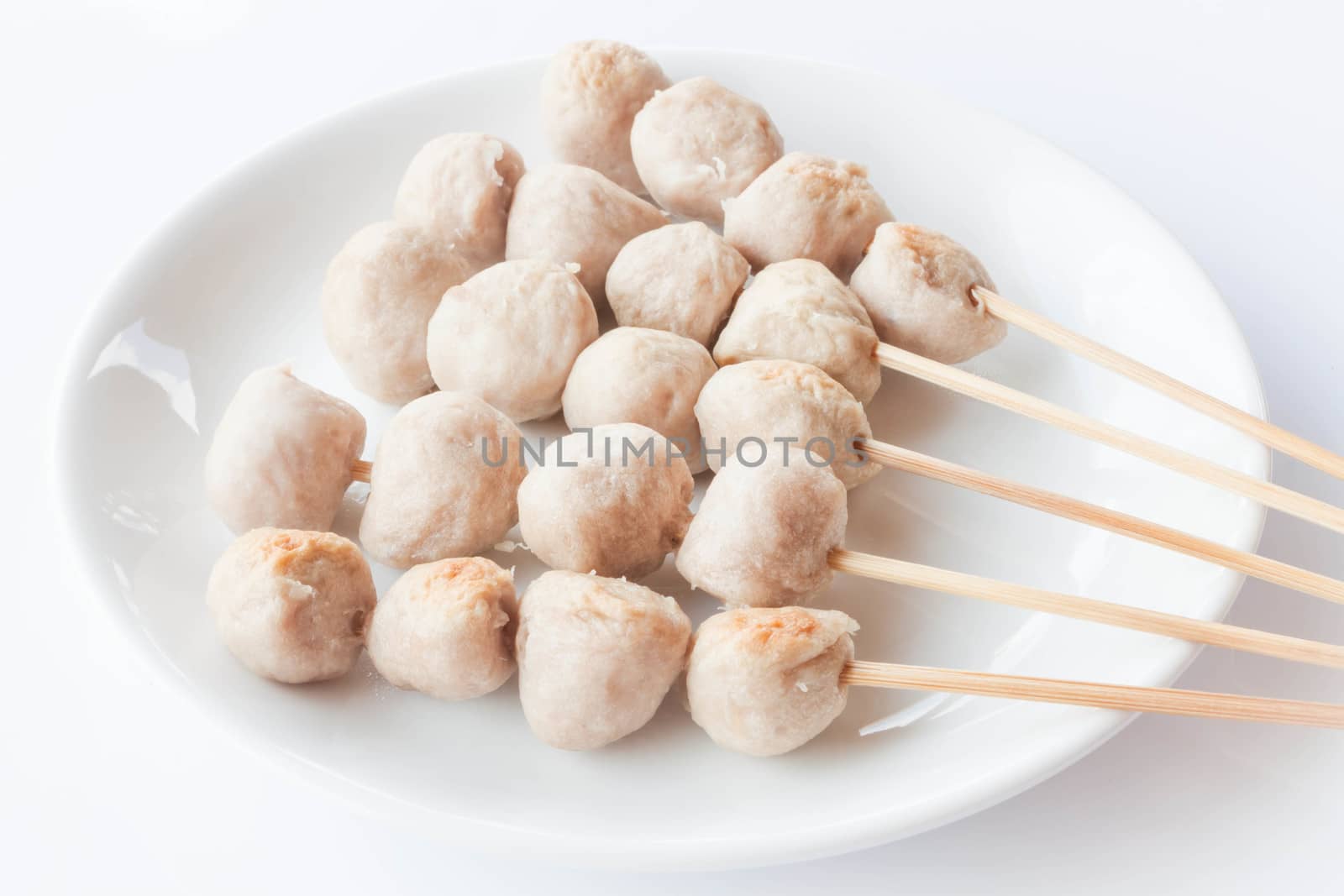 Mini pork balls in white plate on clean table by punsayaporn