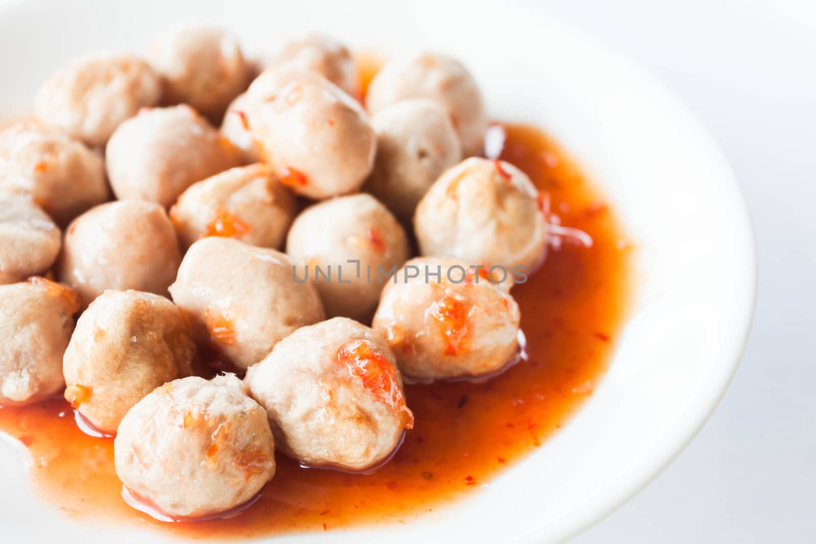 Mini pork balls in orange dish on clean table