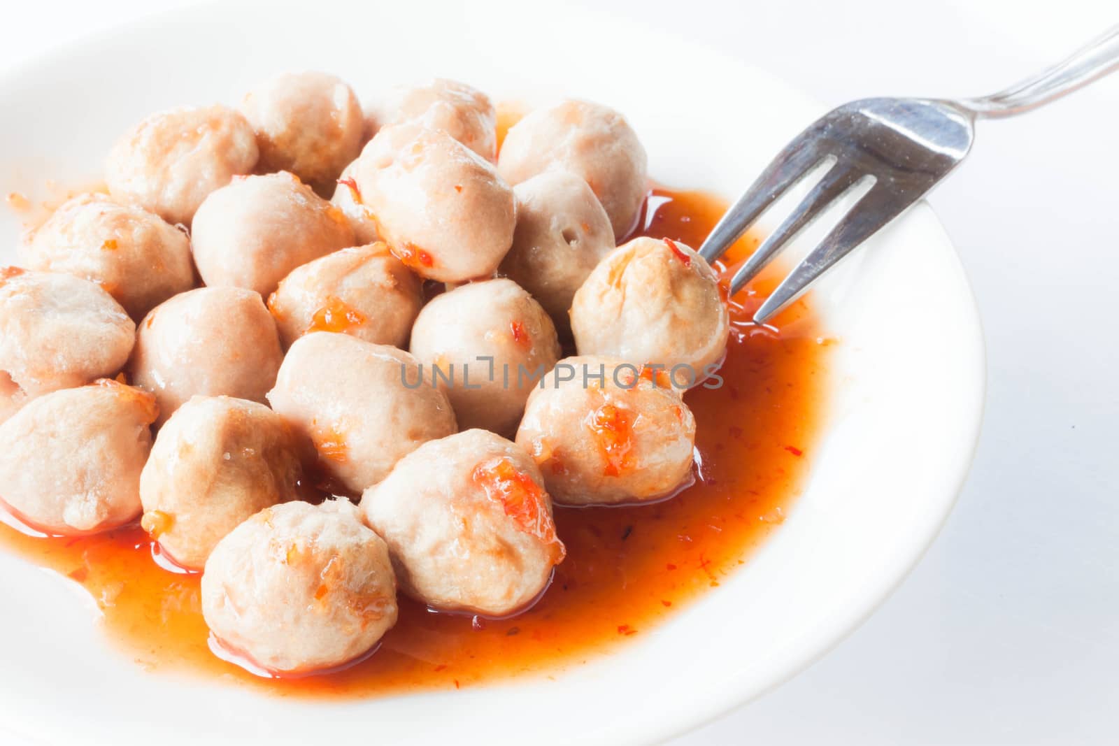 Mini pork balls in orange dish on clean table by punsayaporn
