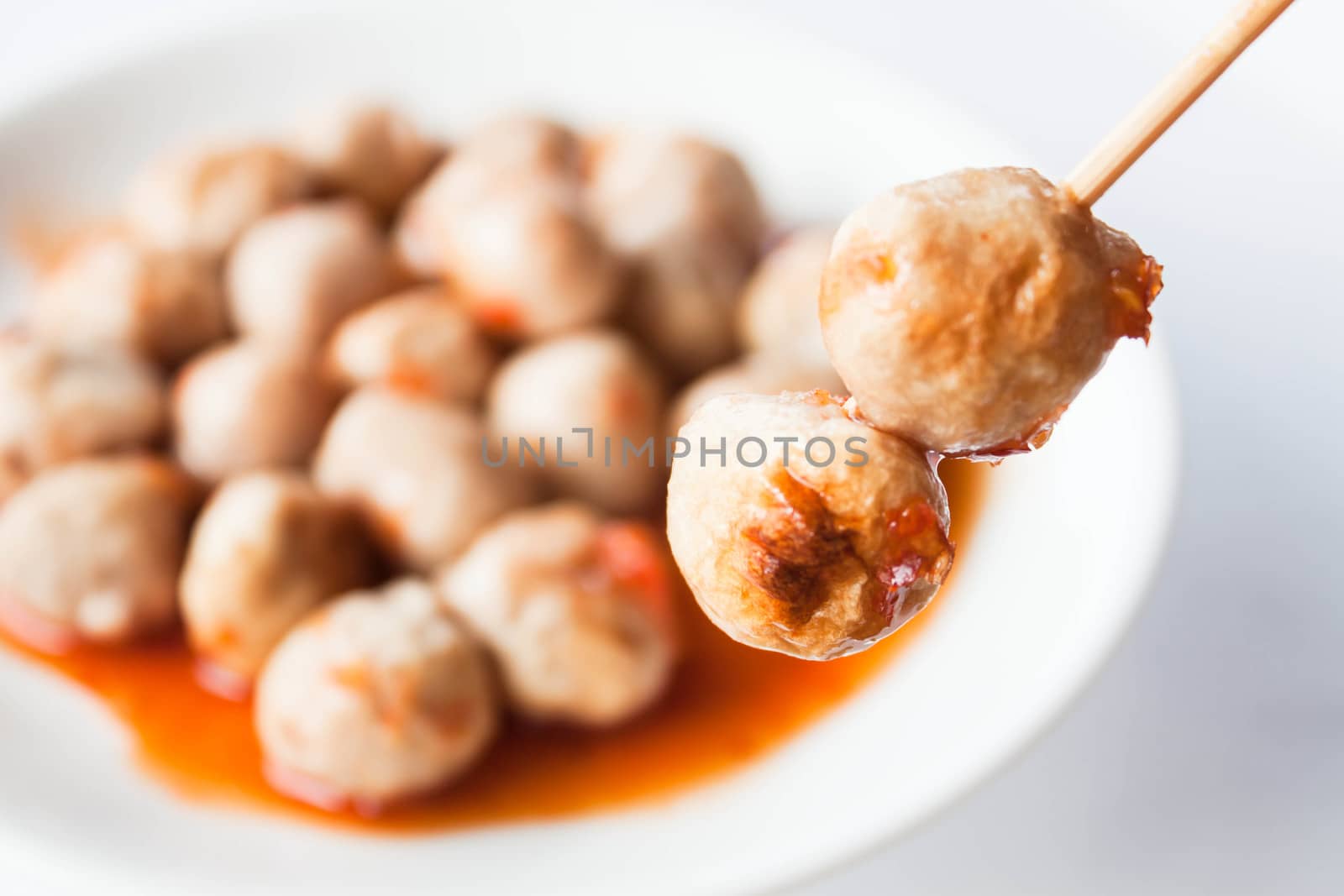 Mini pork balls in orange dish on clean table by punsayaporn