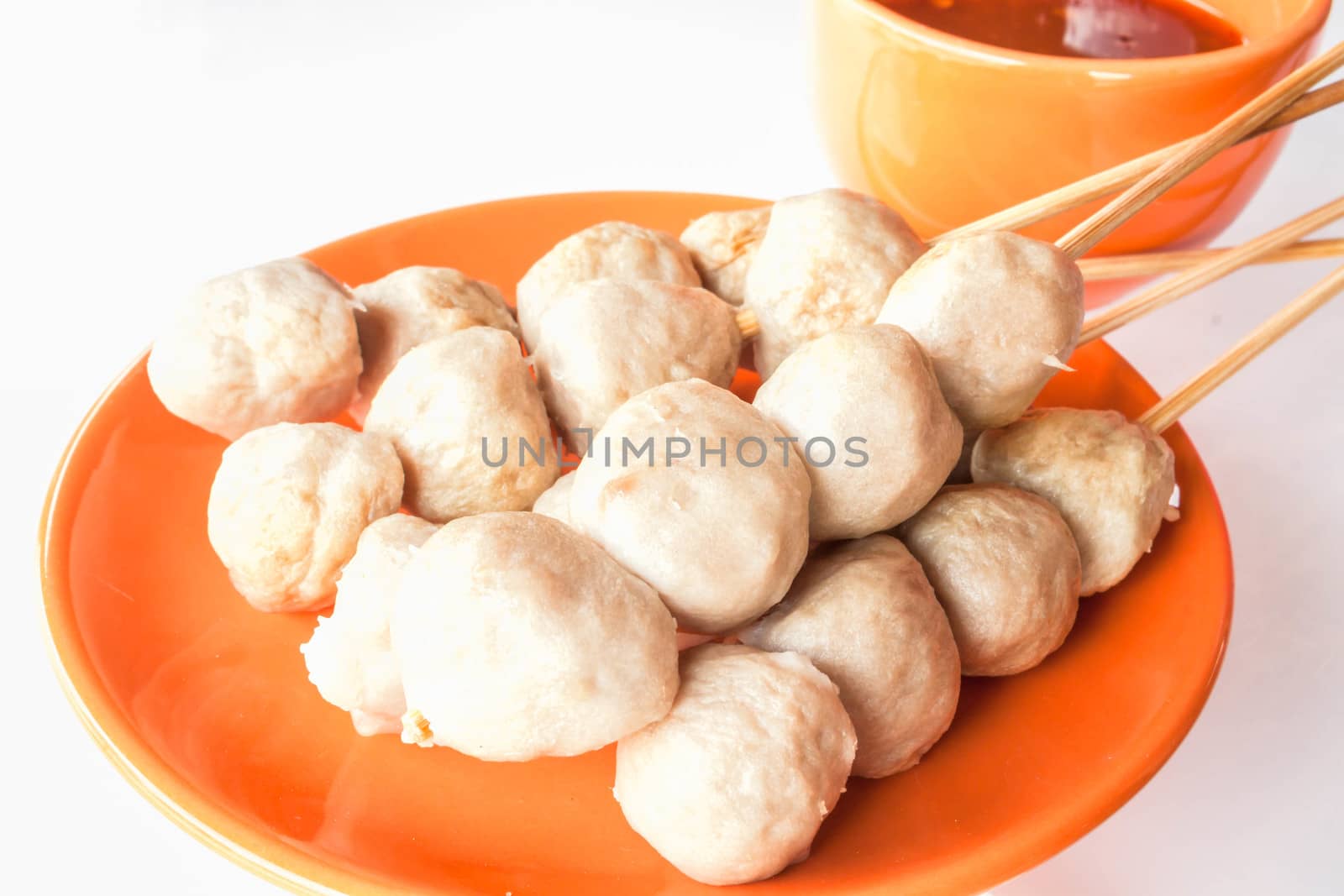 Mini pork balls in orange dish on clean table