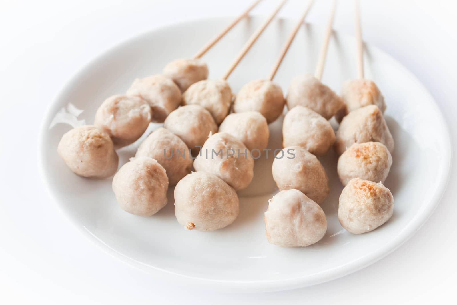 Mini pork balls in white plate on clean table by punsayaporn