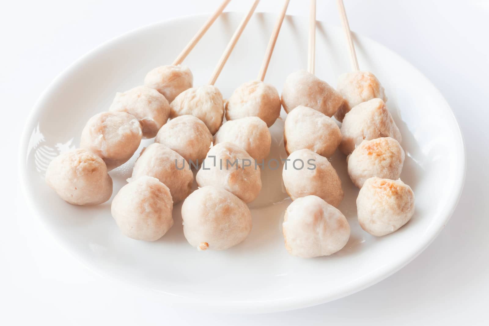 Mini pork balls in white plate on clean table by punsayaporn