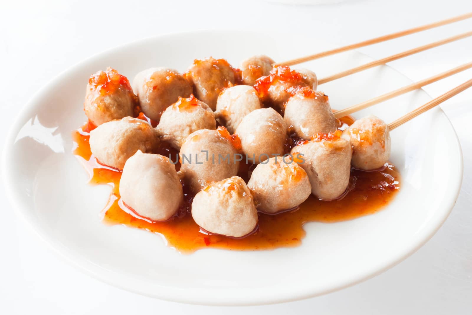 Mini pork balls in white plate on clean table by punsayaporn