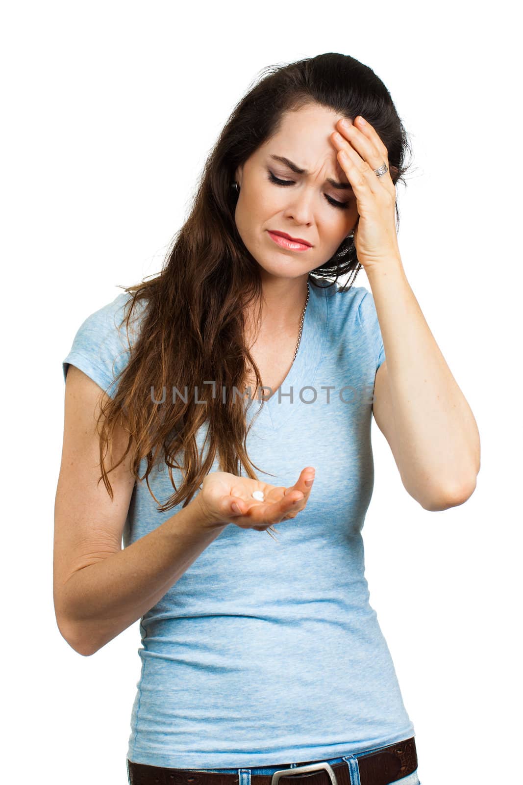 A woman suffering from headache or migraine holding a painkiller pill. Isolated on white.