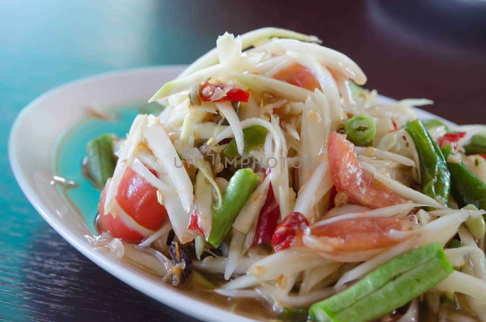 close up spicy papaya salad and vegetable on white dish
