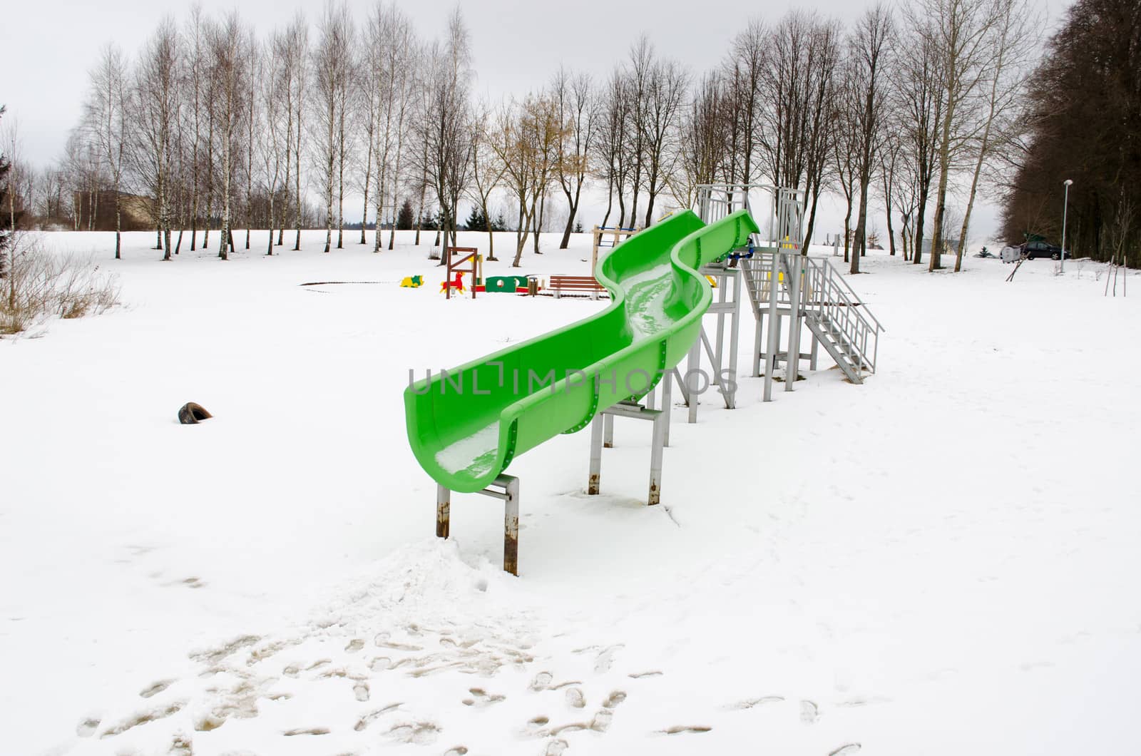 outdoor water park slide on frozen snowy lake in winter playground.