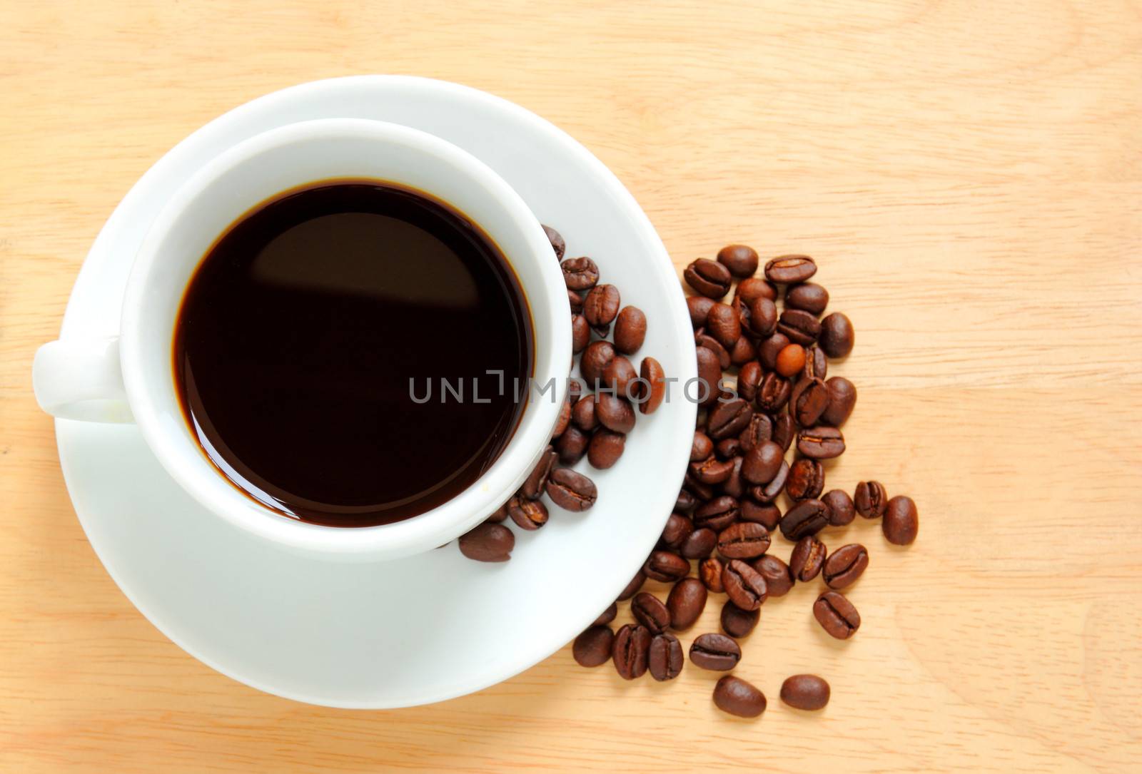 Coffee cup and beans on wooden table