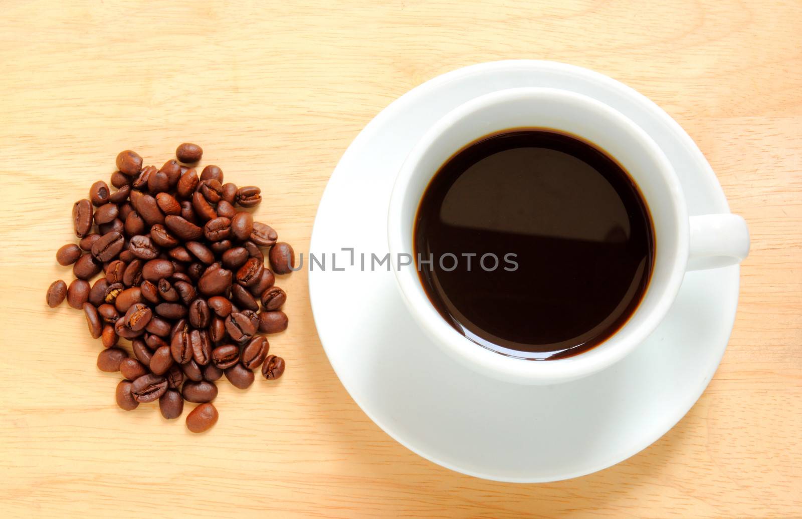 Coffee cup and beans on wooden table by nuchylee