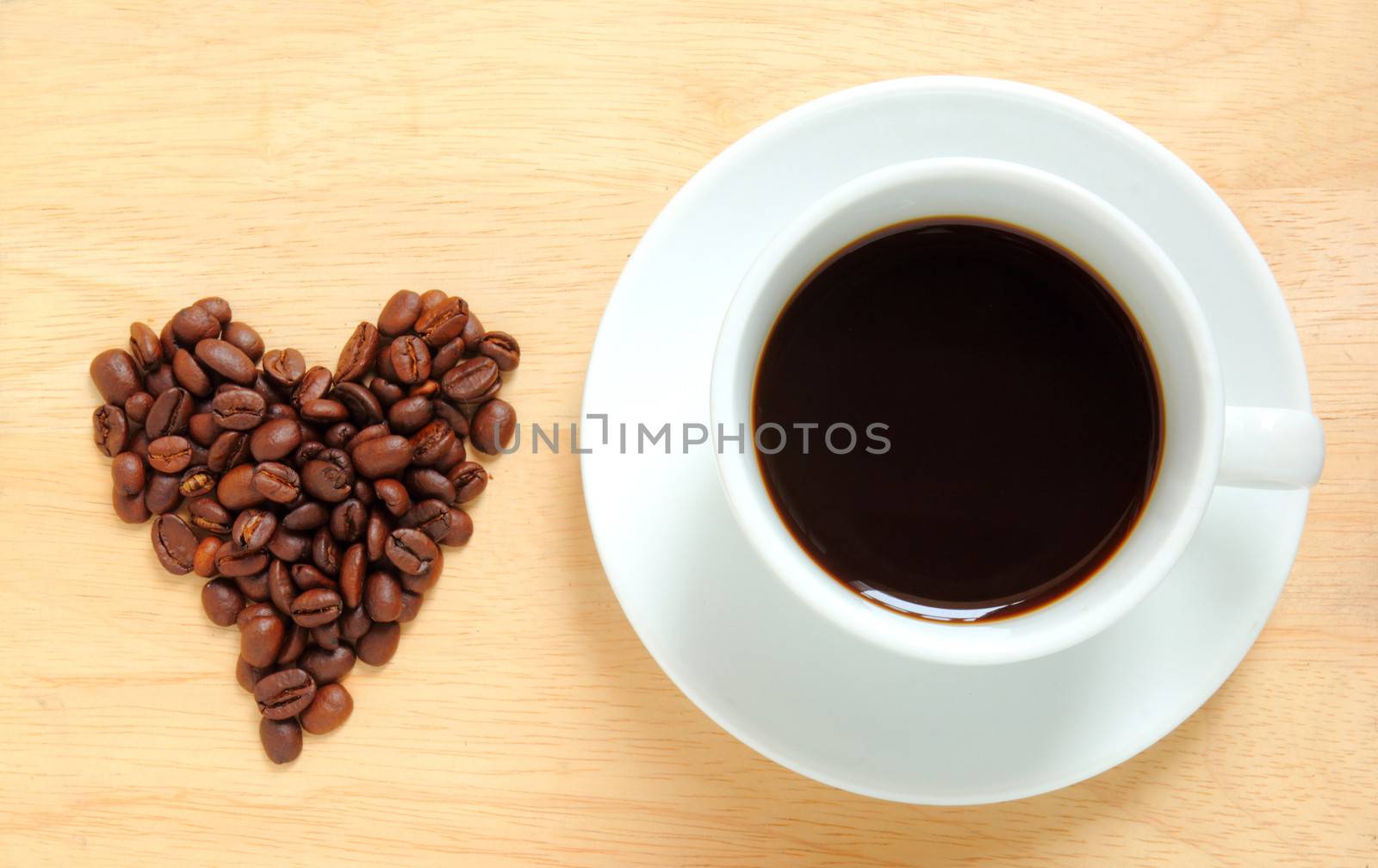 Heart shape made from coffee beans with a cup of coffee