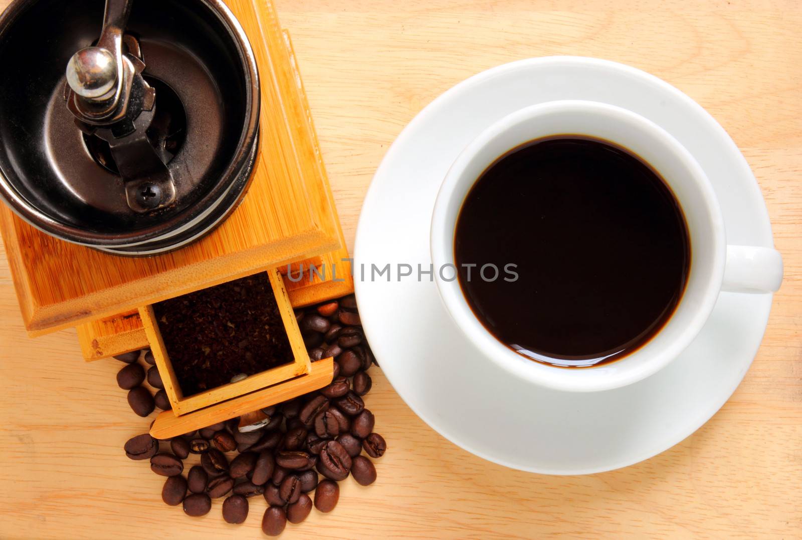 Cup of hot coffee with coffee grinder and beans  by nuchylee