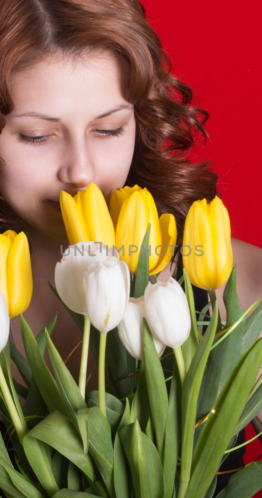 lovely girl with a bouquet of tulips on red background