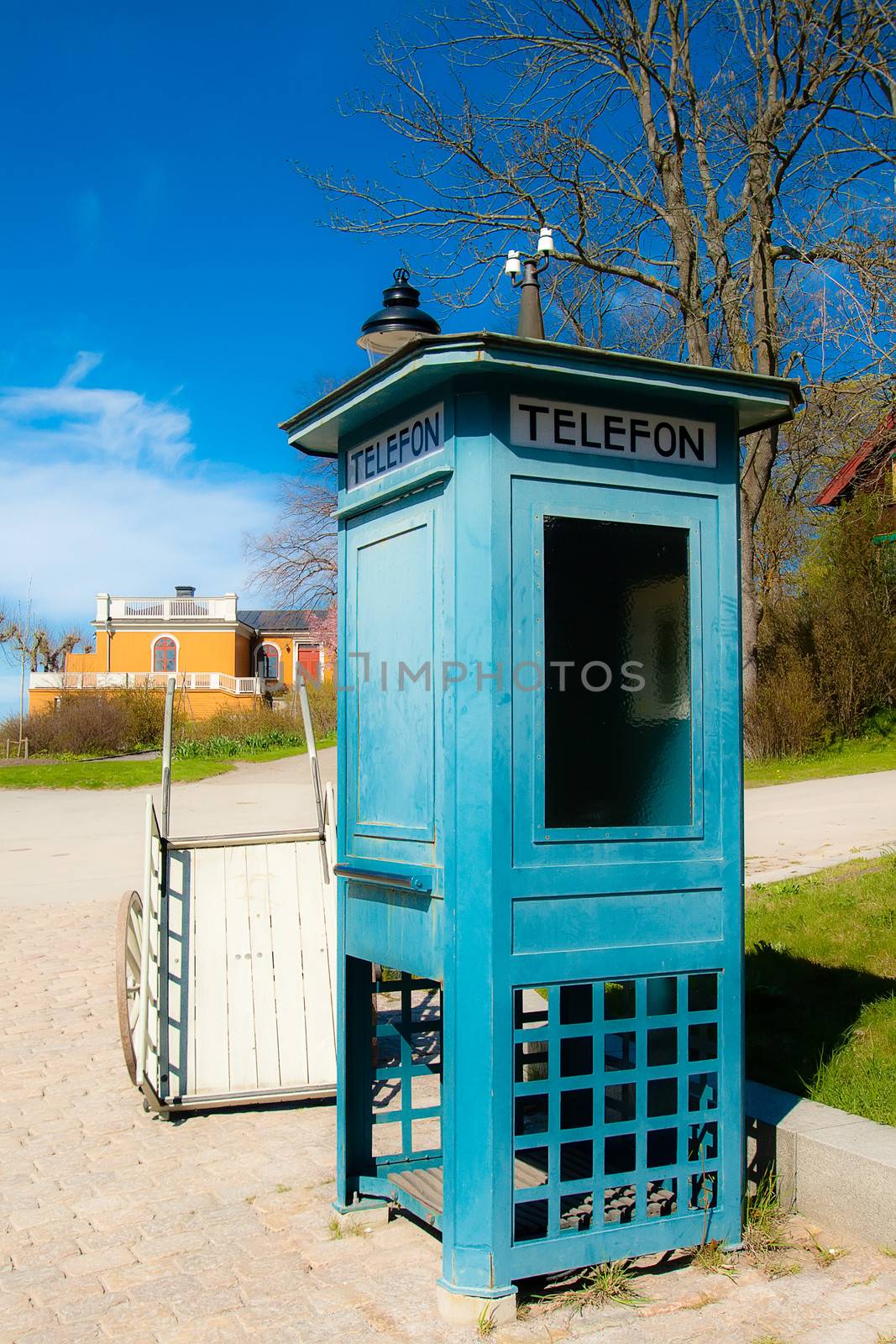Antique telephone booth and a cart in the park Skansen in Stockholm