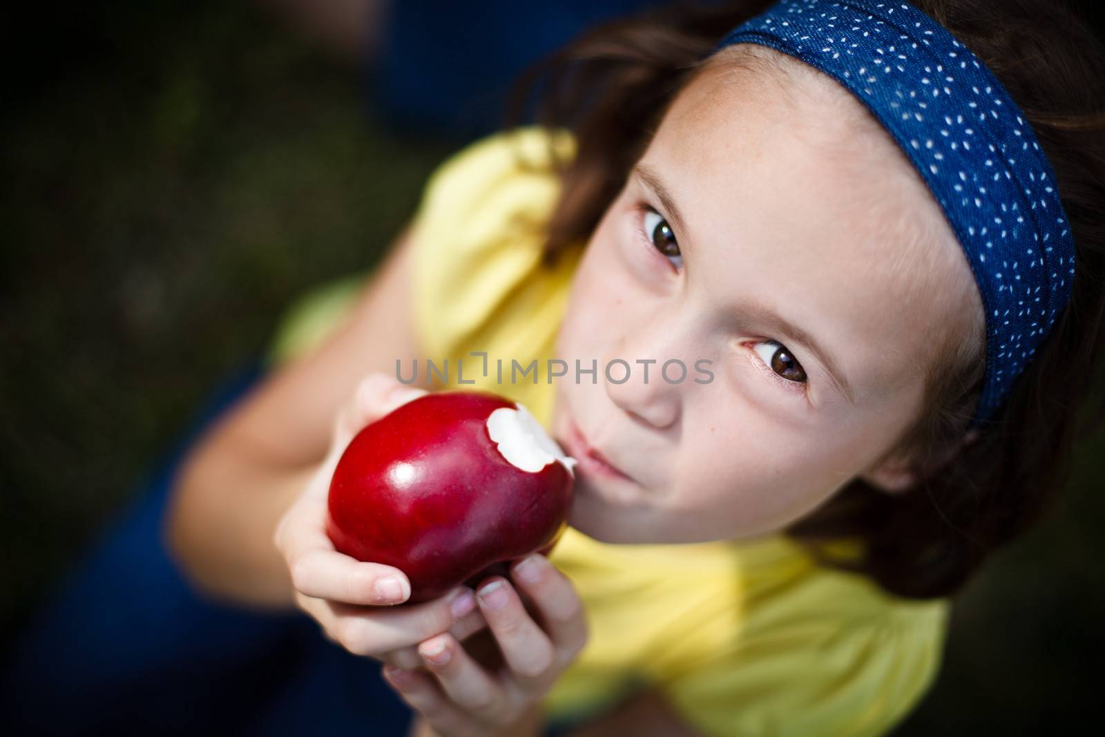 Cute little girl eating an apple