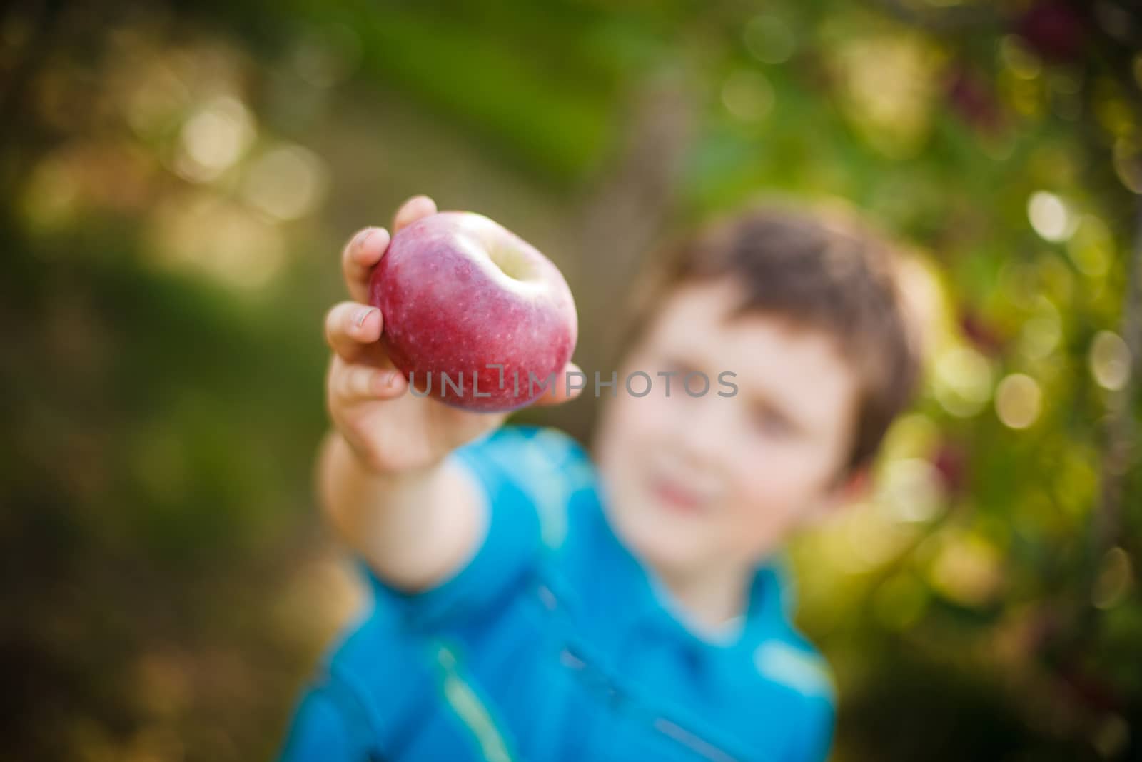 Boy holding an apple by Talanis