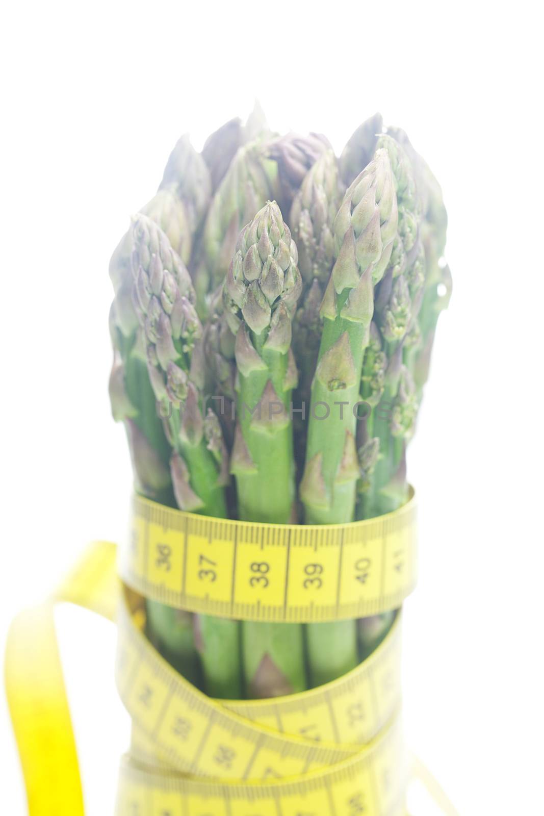 asparagus tied with measuring tape isolated on white by jannyjus