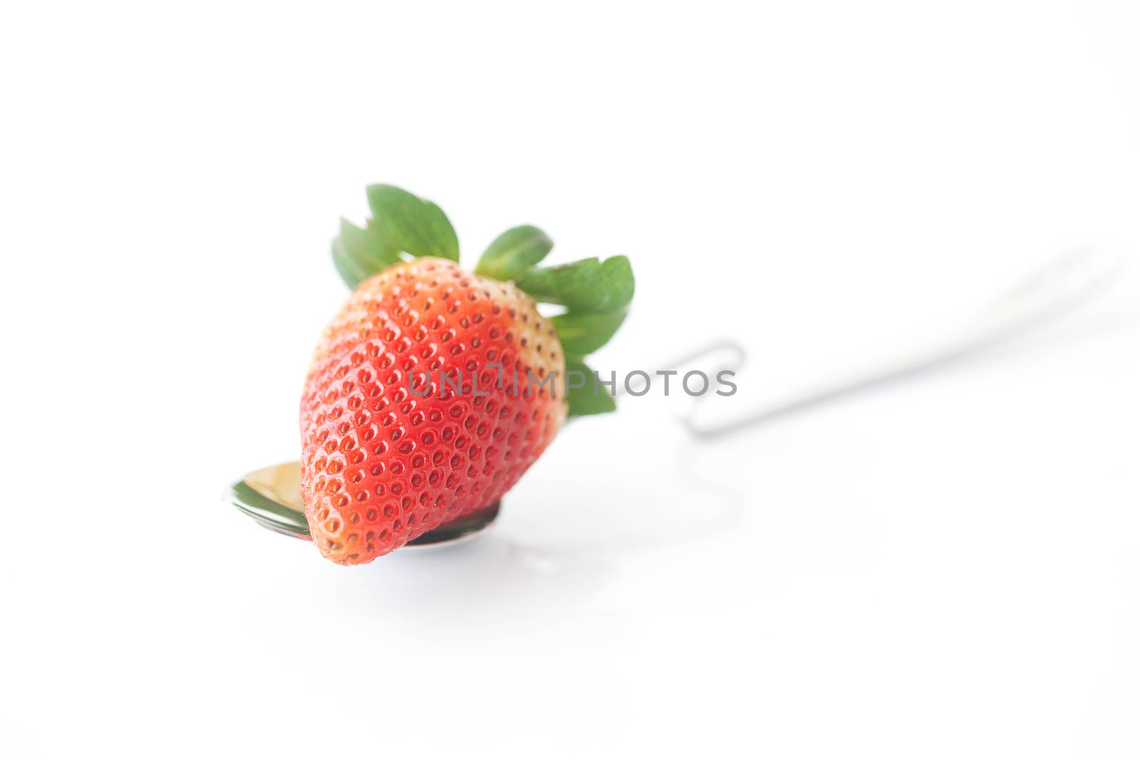 big red strawberry and spoon isolated on white