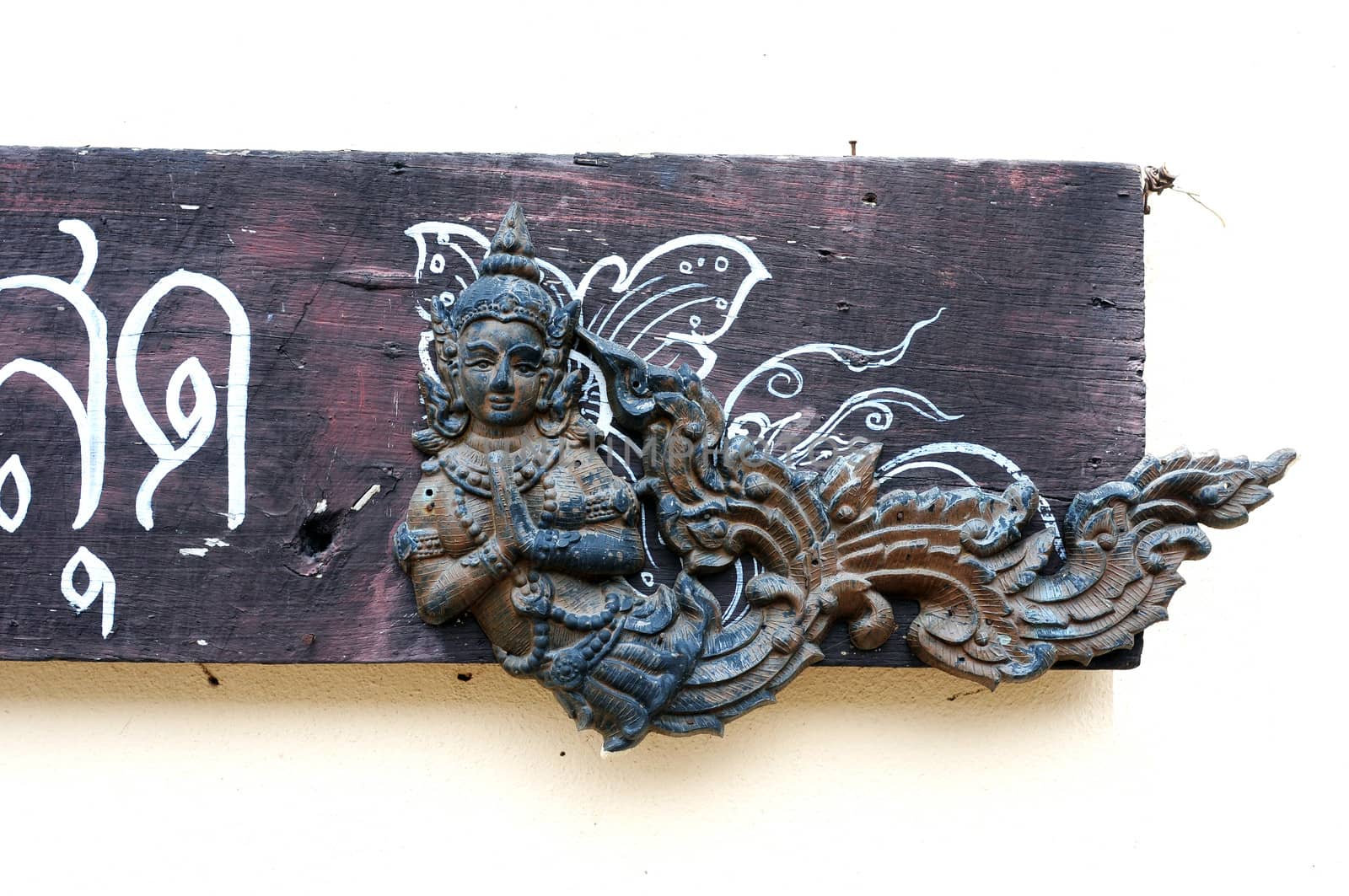 Wooden carving art of a Thai angel on a  doorplate