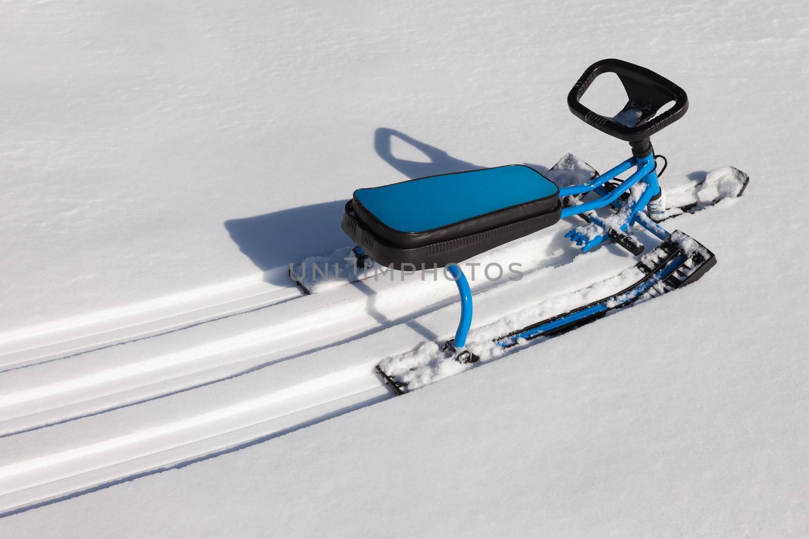 Scooter or snowmobile toy on winter snow hill