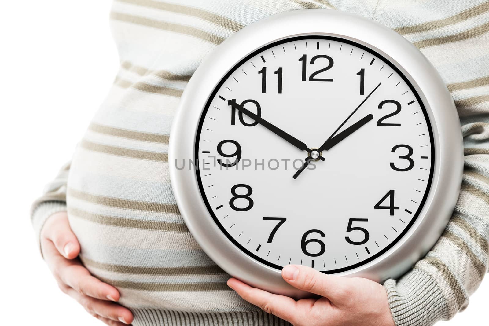 Pregnant woman hand holding large office wall clock showing time by ia_64