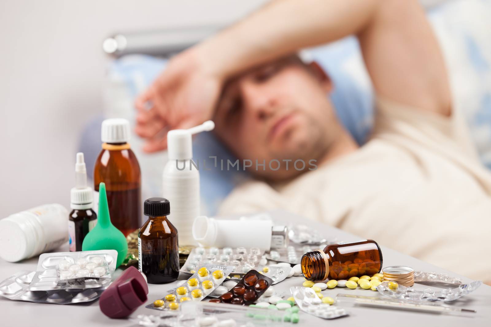 Adult man patient with high temperature lying down bed for cold and flu illness relief