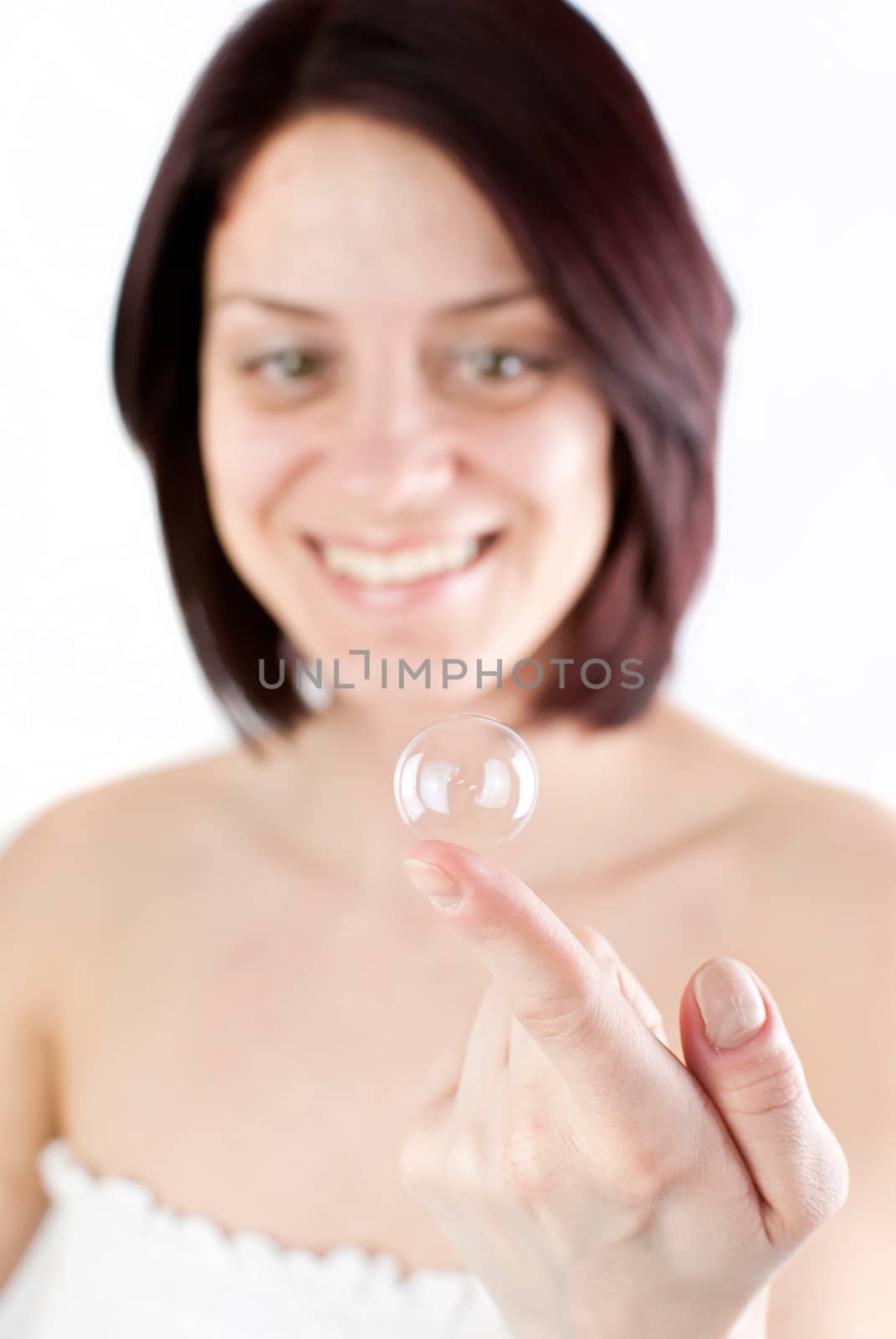 young attractive woman holding soap bubble on her finger