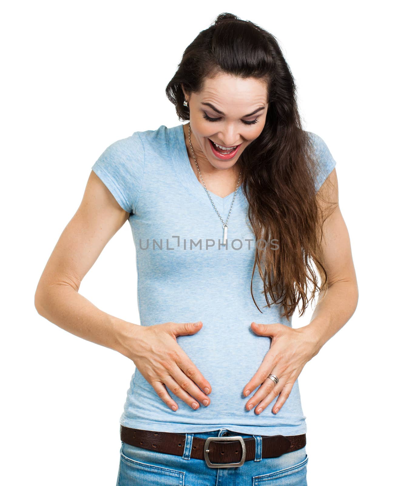 A happy newly pregnant woman smiling and looking and holding tummy. Isolated on white.