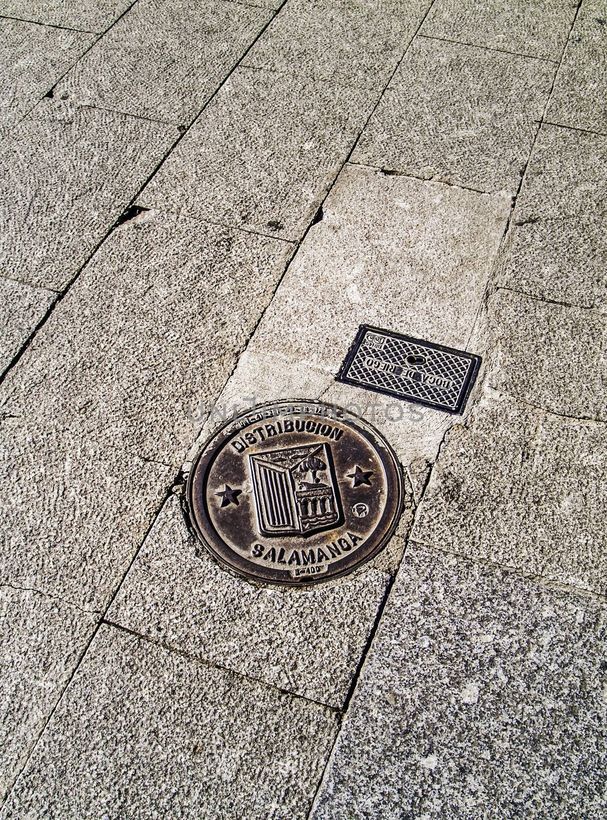 Salamanca, December 2012. Water supply lids with the coat-of-arms of Salamanca in the street pavement.  City of Castilla and Leon region. 150,000 population. UNESCO World Heritage Site since 1988.