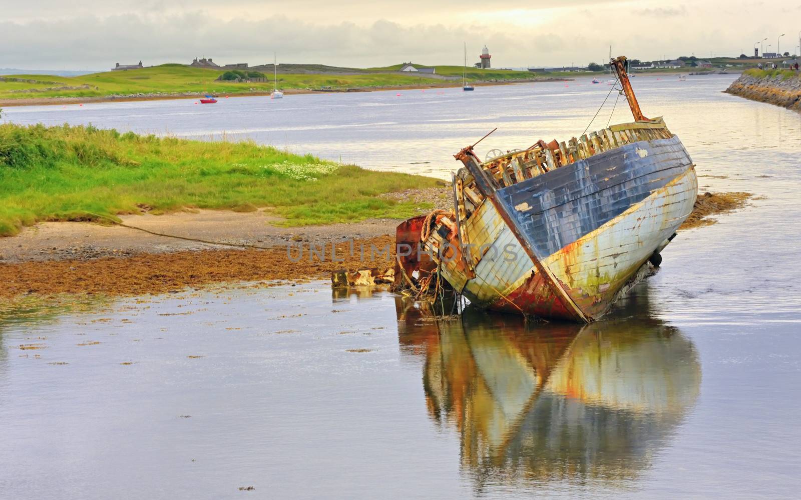 boat wreck lying on the shore of lake by mady70