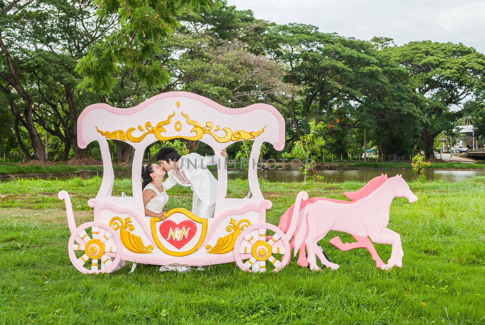 Asian Thai bridal is kissing in romantic carriage with love theme as the Prince and Princess.