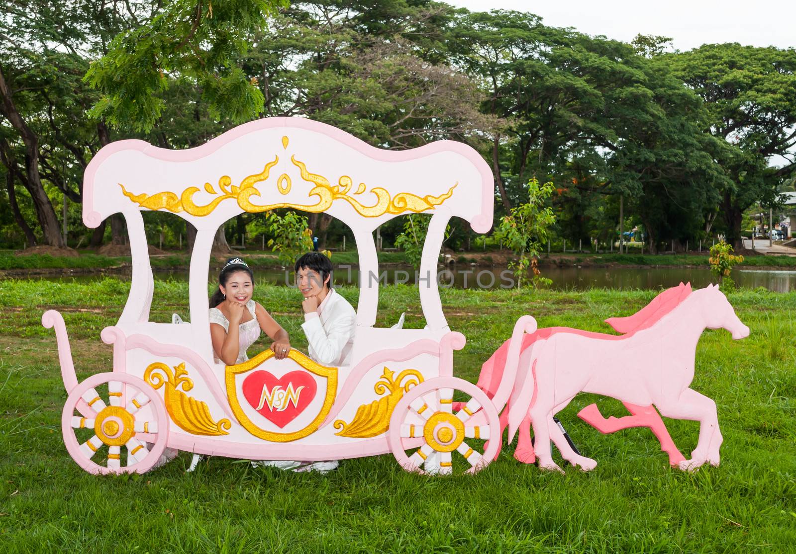 Asian Thai bridal is sitting in romantic carriage with love theme as the Prince and Princess.