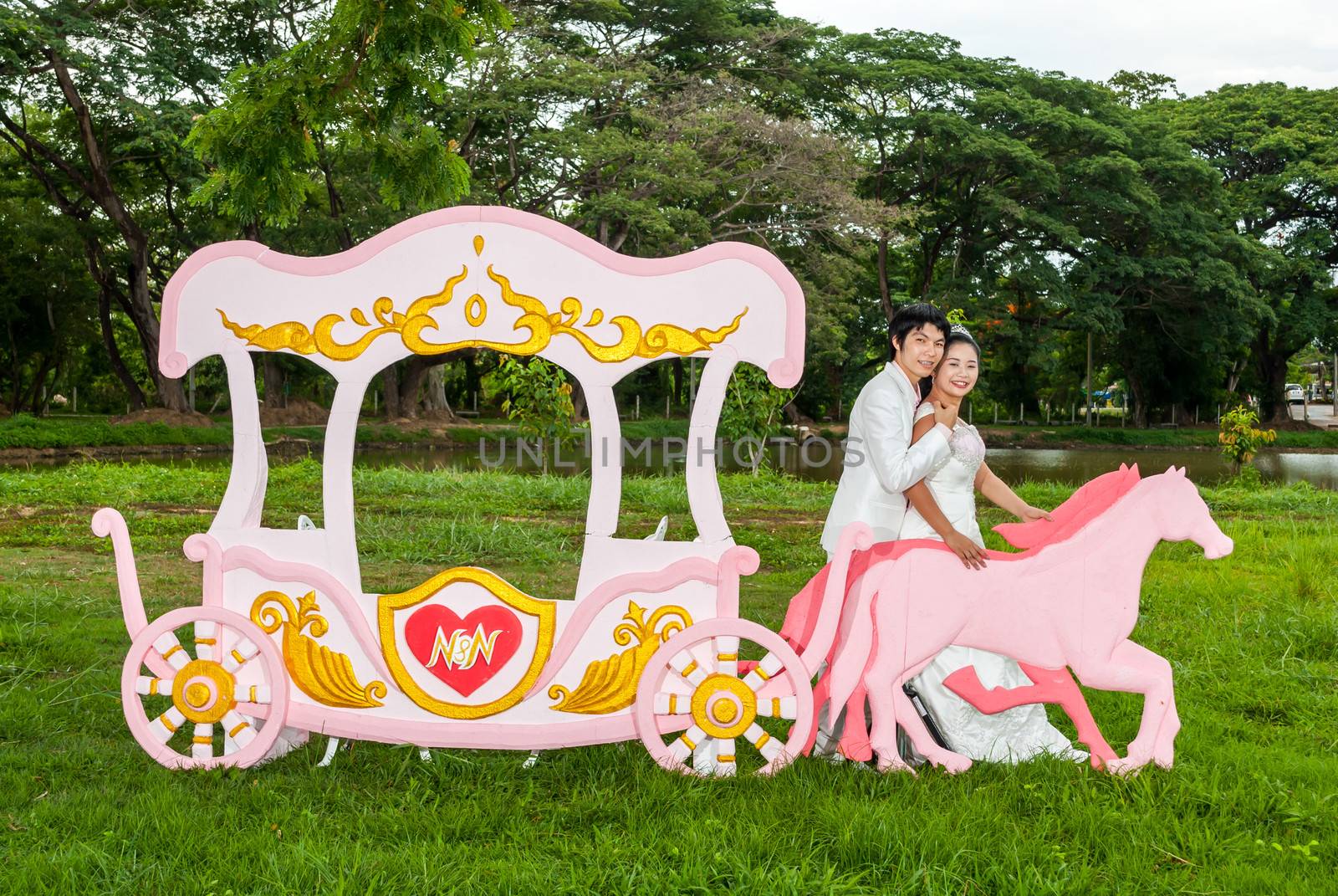 Asian Thai bridal is standing with the horse beside romantic carriage with love theme as the Prince and Princess.