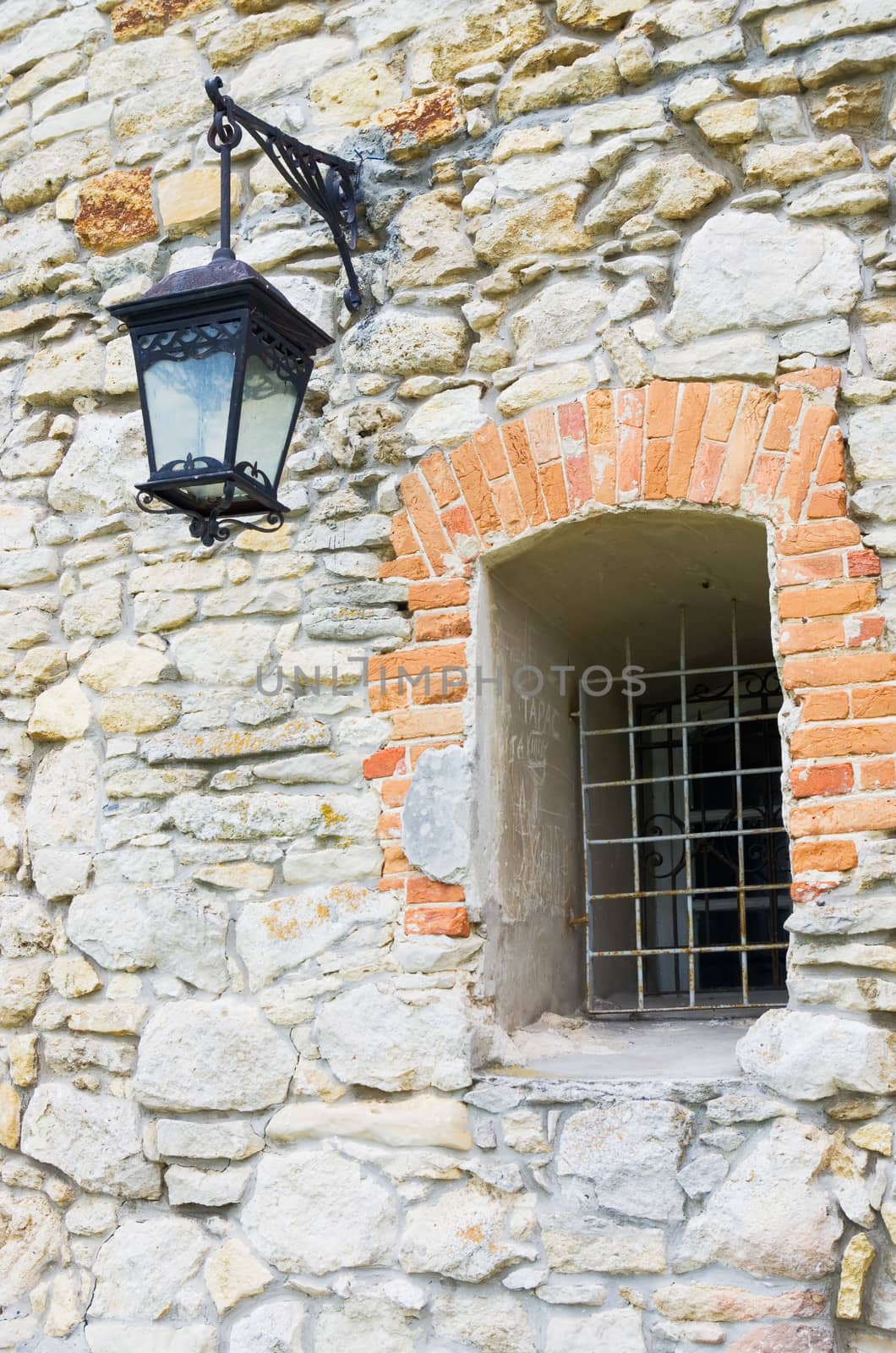 Old wall made from stone with window and streetlight