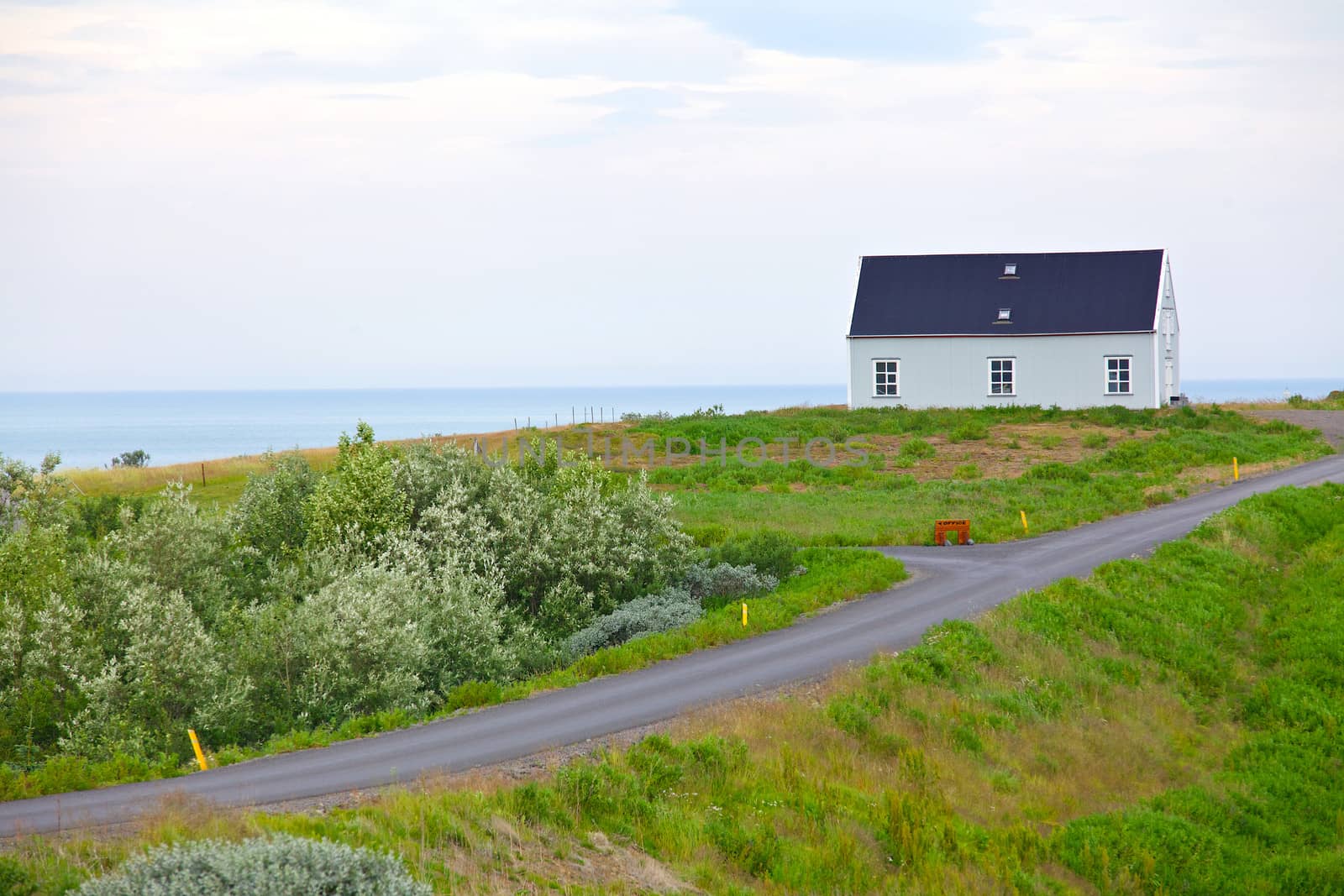 Beautiful house in Iceland. Mountains in background.