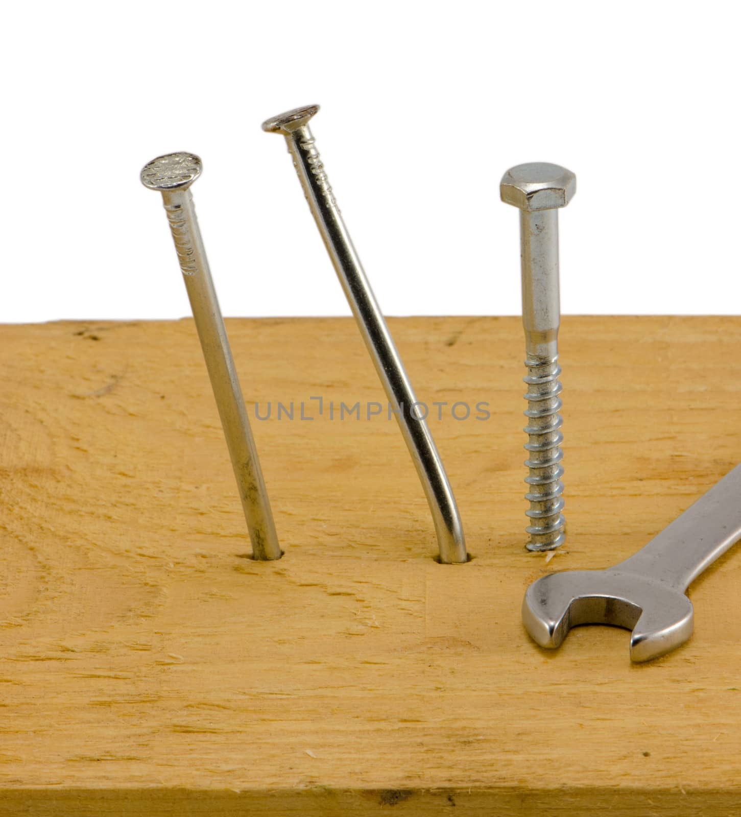 bend nails hammered to board and screw bolt with wrench tool head isolated on white background.