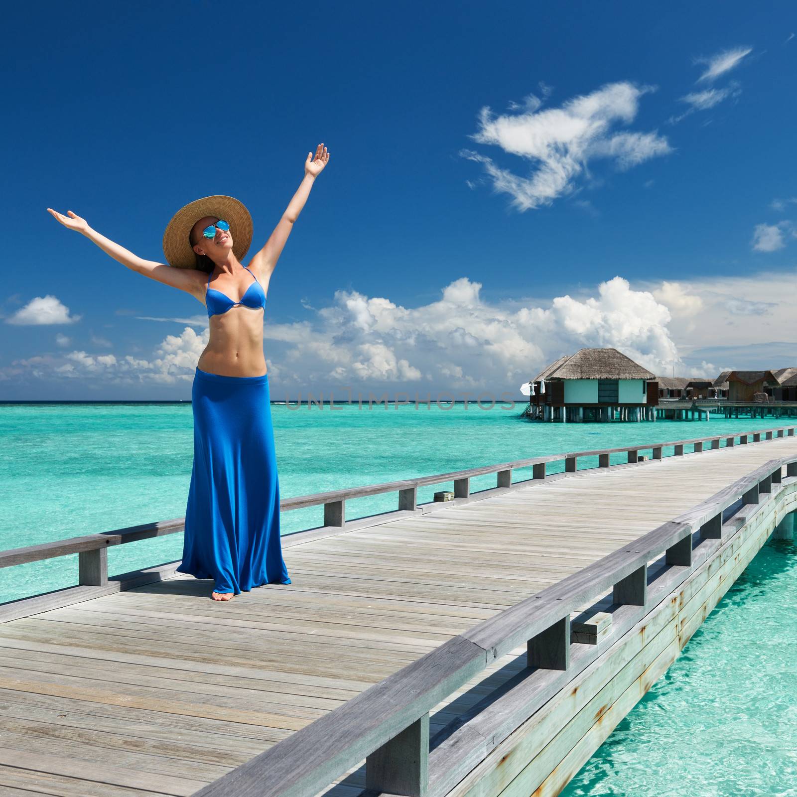 Woman on a tropical beach jetty at Maldives