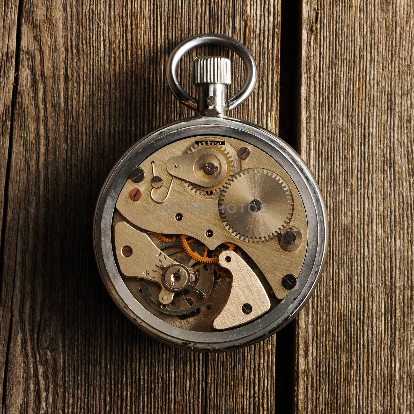 Clockwork mechanism over wooden background 