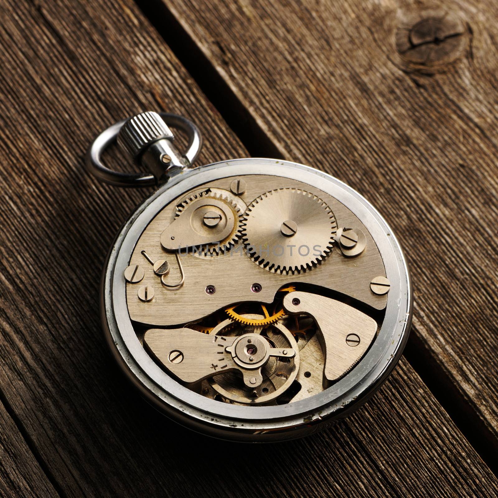 Clockwork mechanism over wooden background 