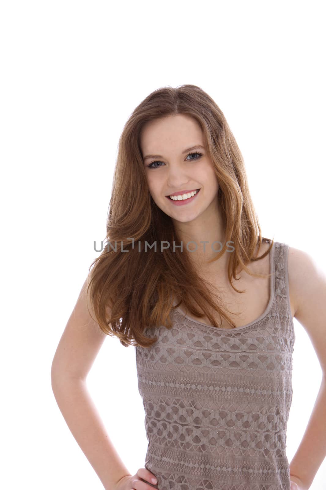Pretty trendy teenage girl standing with her hands on her hips smiling at the camera isolated on white
