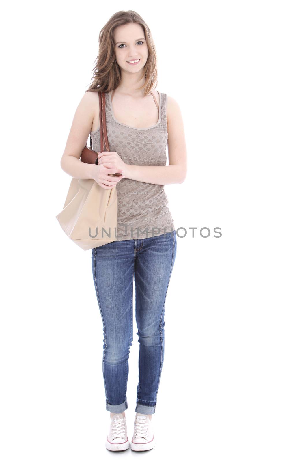 Trendy young female student wearing jeans and a pretty summer top and carrying a large cloth bag over her shoulder, full length portrait on white