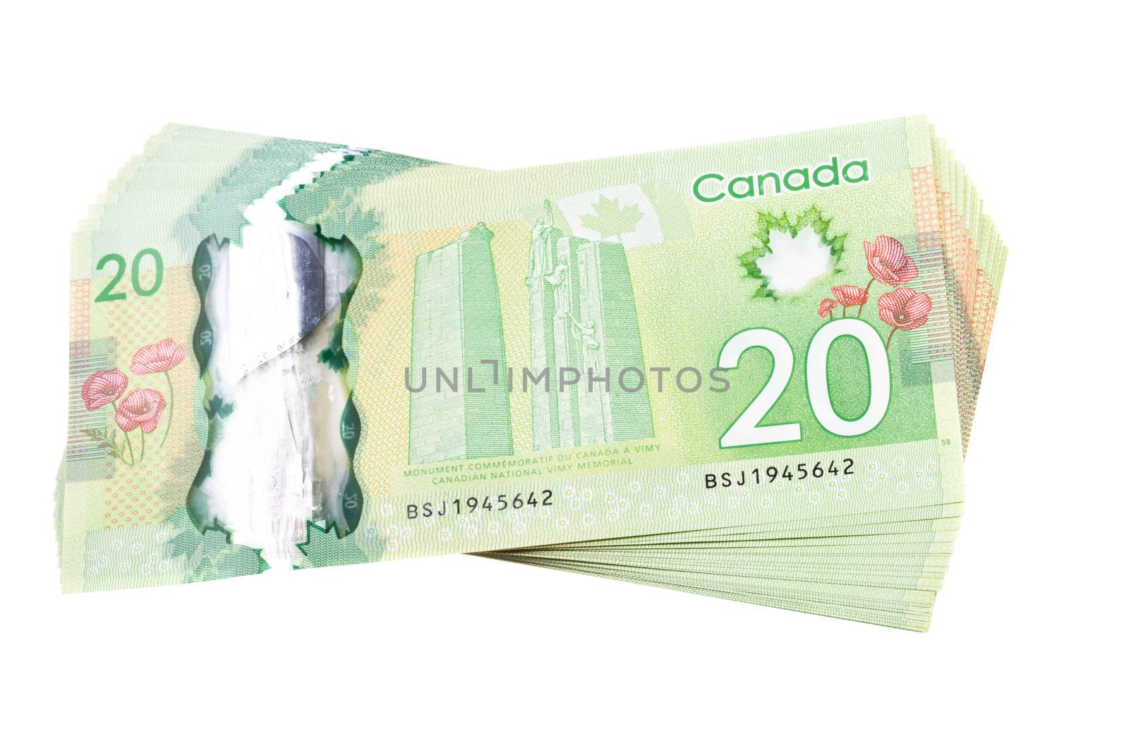 A stack of new polymer Canadian twenty dollar bills, isolated on white background