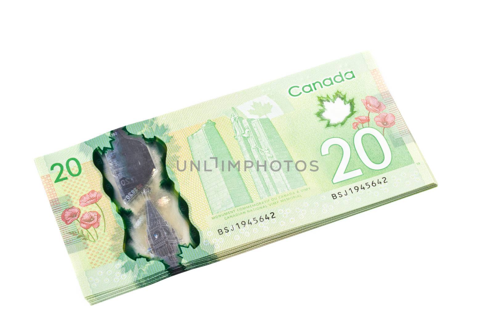 A stack of new polymer Canadian twenty dollar bills, isolated on white background