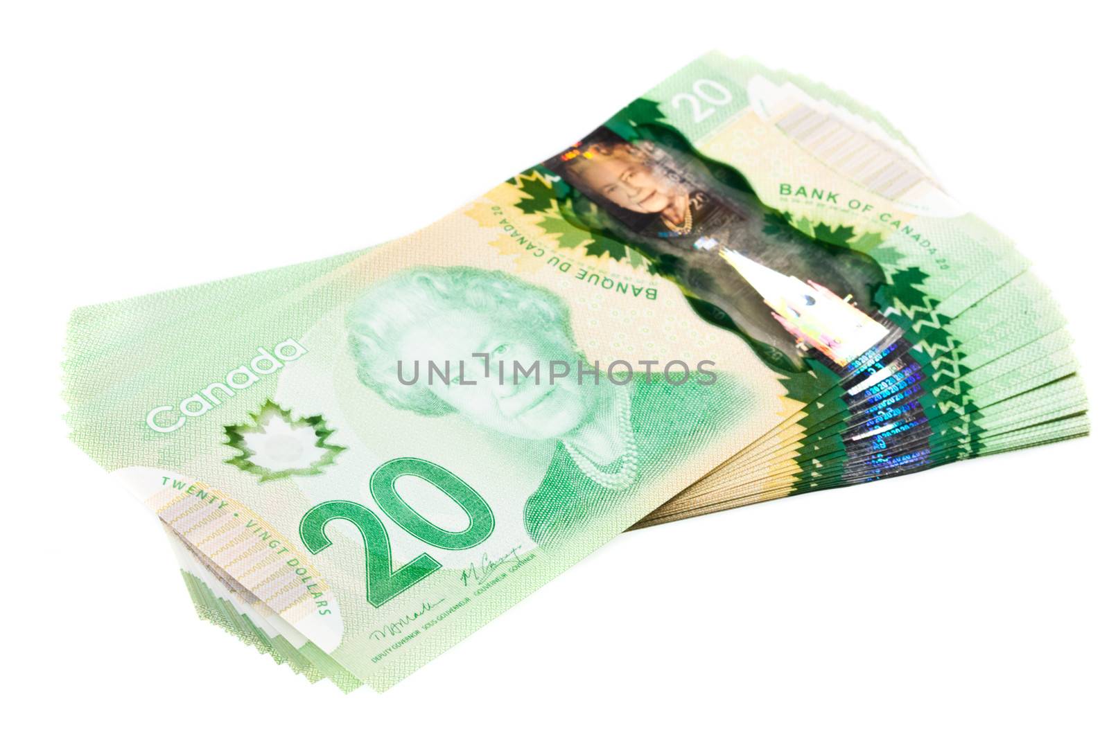 A stack of new polymer Canadian twenty dollar bills, isolated on white background