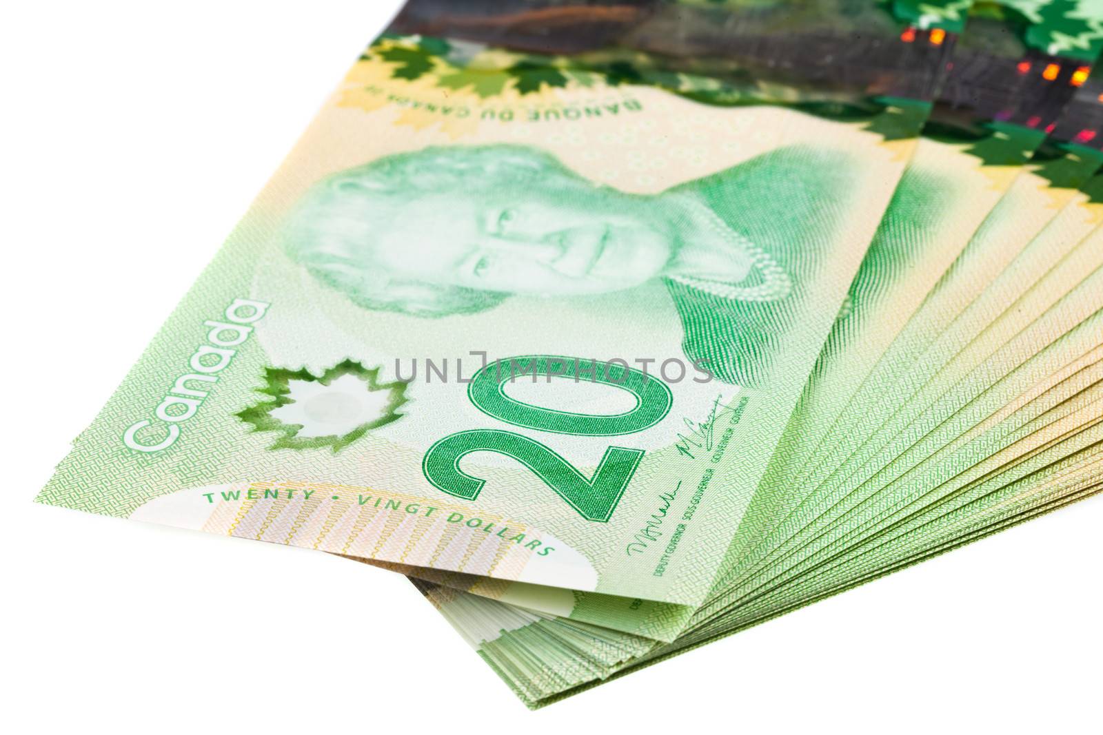 A stack of new polymer Canadian twenty dollar bills, isolated on white background