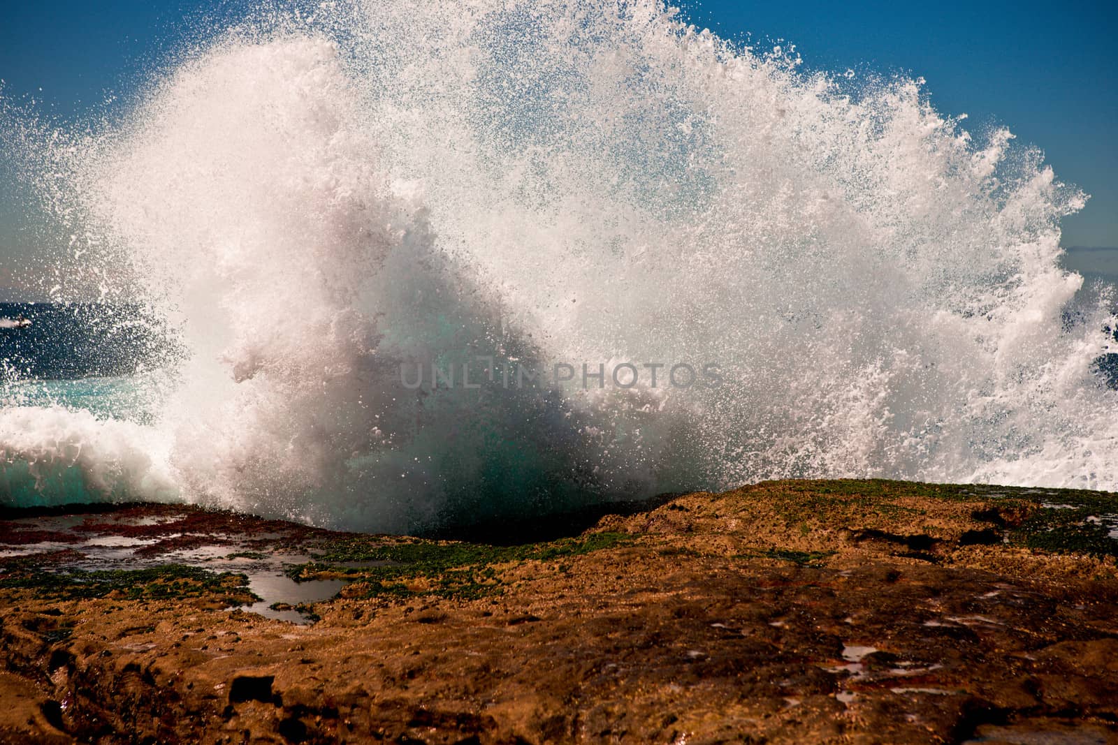 Big wave breaking on rocks by jrstock